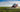 tractor spraying atrazine pesticide onto a field of corn