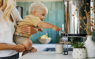 Kid pouring boroux water into a cup ready to drink filtered water