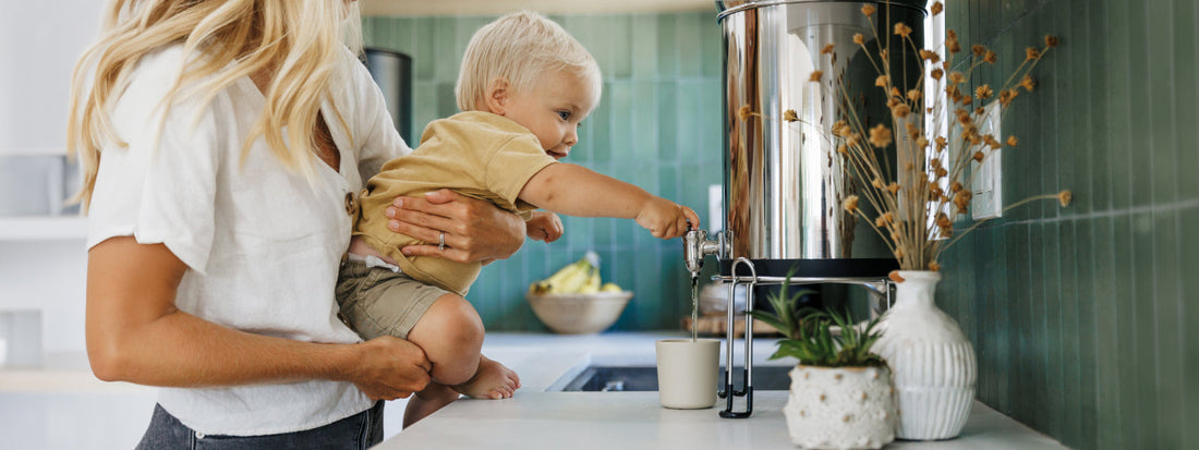 Kid pouring boroux water into a cup ready to drink filtered water