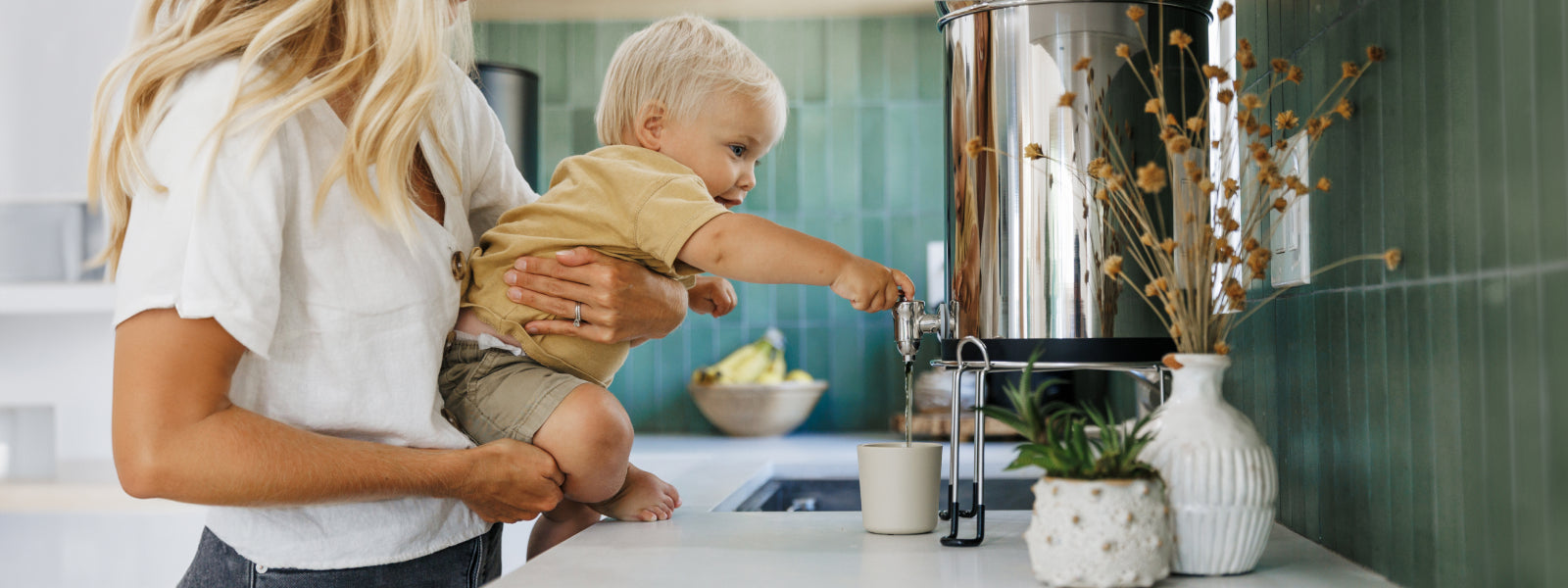 Kid pouring boroux water into a cup ready to drink filtered water