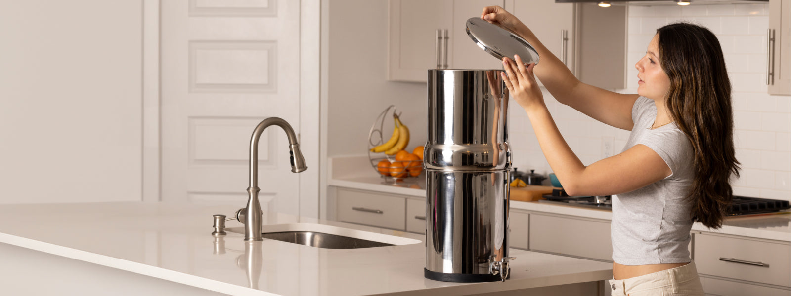 Woman placing lid on a BOROUX legacy water filter system