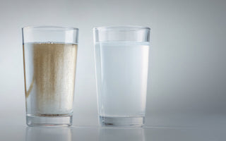 Glass of contaminated water that contains glass of water with sediment and silt