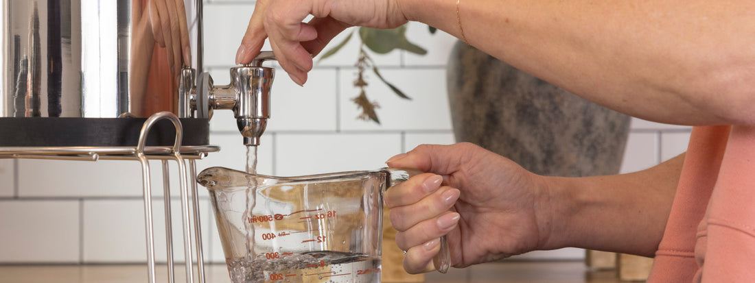Woman pouring BOROUX water into a measuring cup to start making sourdough 