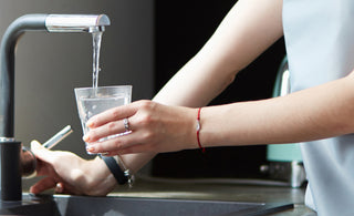 Woman filling cup with tap water