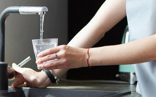 Woman filling cup with tap water