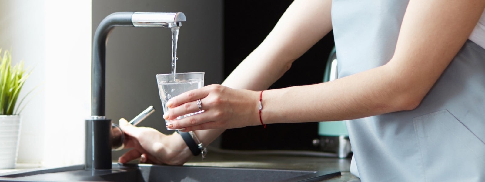 Woman filling cup with tap water
